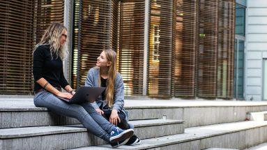 two women having conversation on stairs